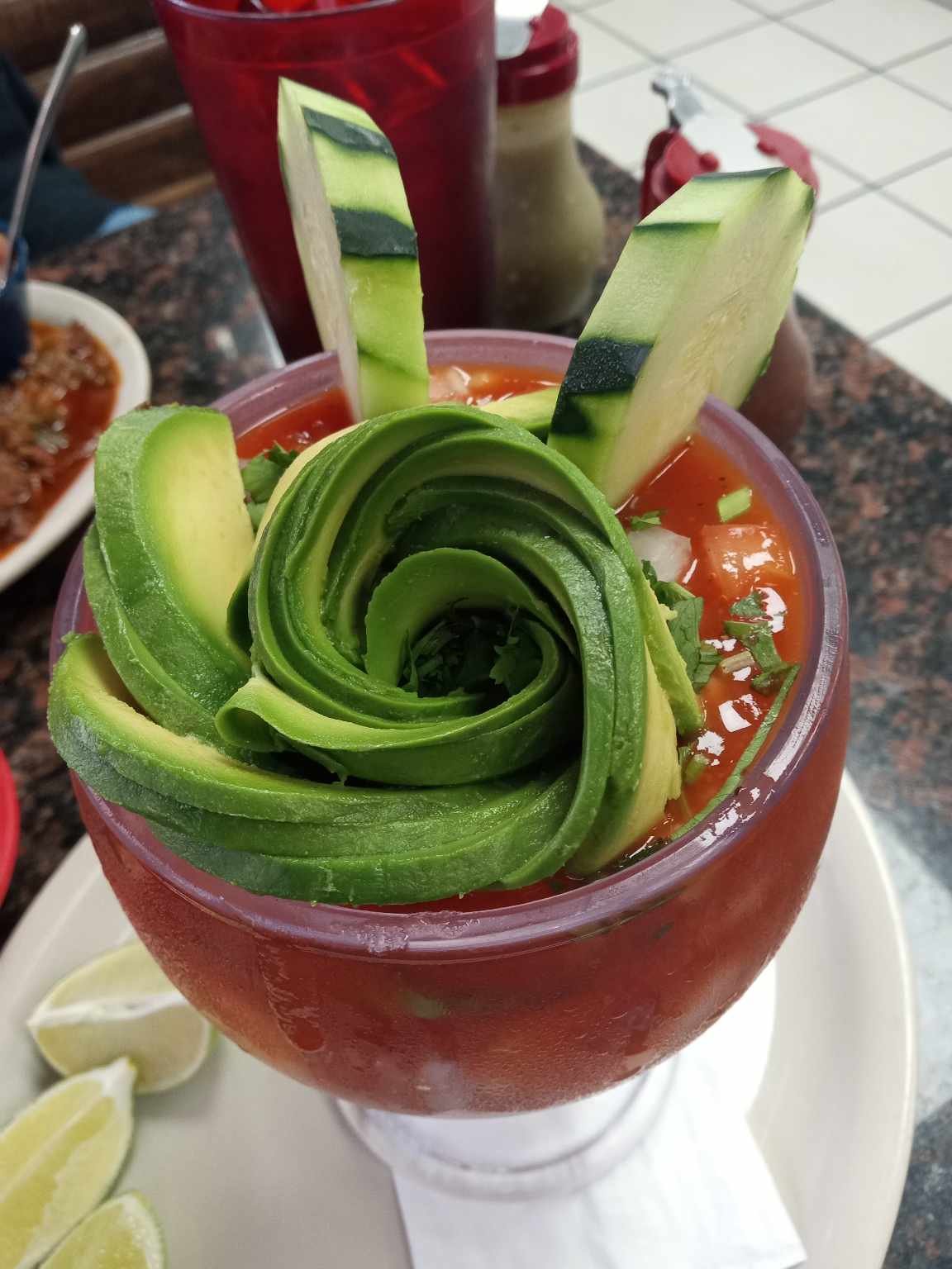 Michelada garnished with an avocado rose and cucumber